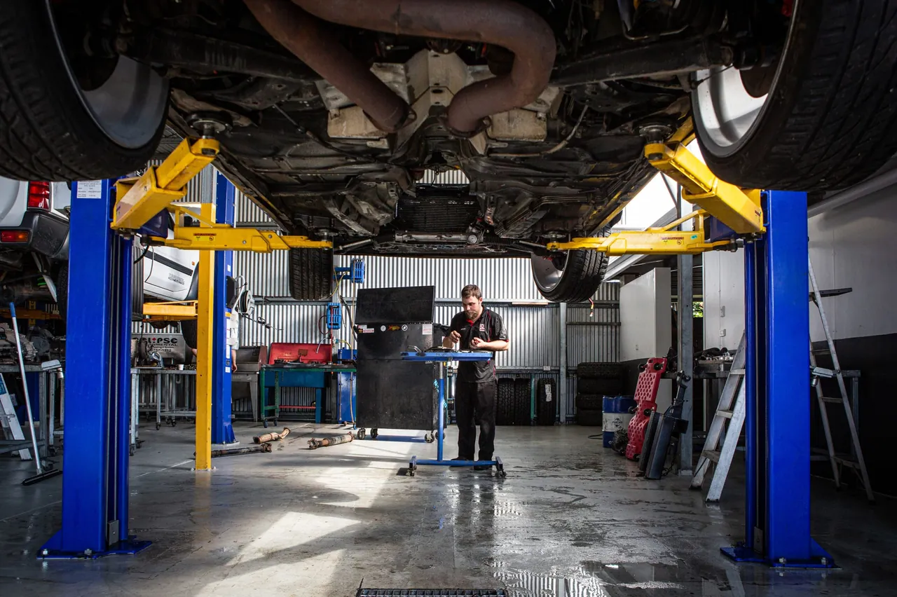 The Everything Automotive workshop in Woree, with a row of blue hoists and cars raised