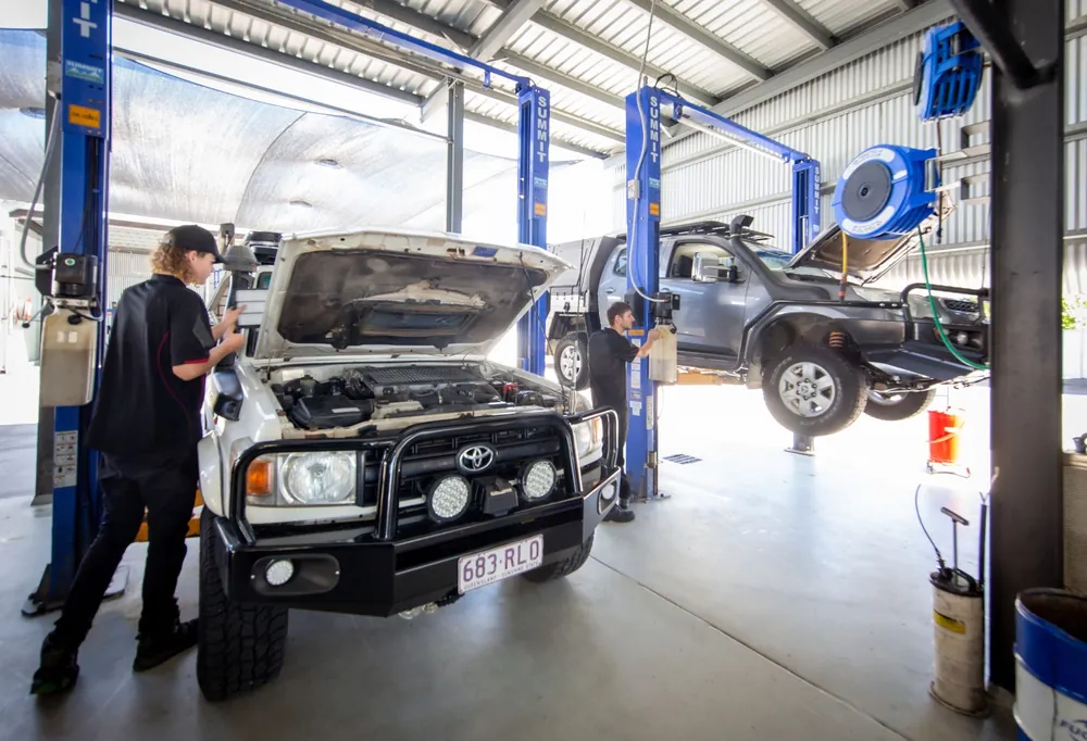 A LandCruiser with its bonnet up in the workshop